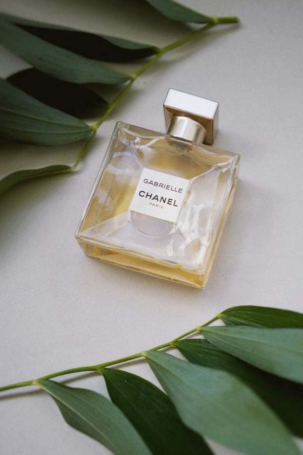 Gabrielle Chanel Perfume bottle surrounded by leaves